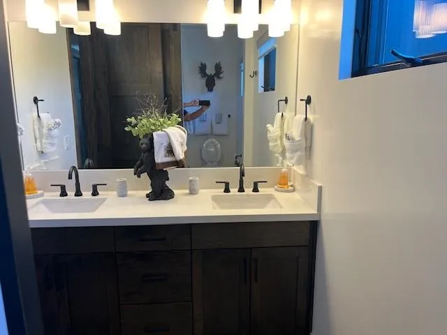 a bathroom with double vanity sinks and a mirror