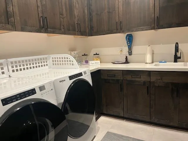 a utility room with sink dryer and washer