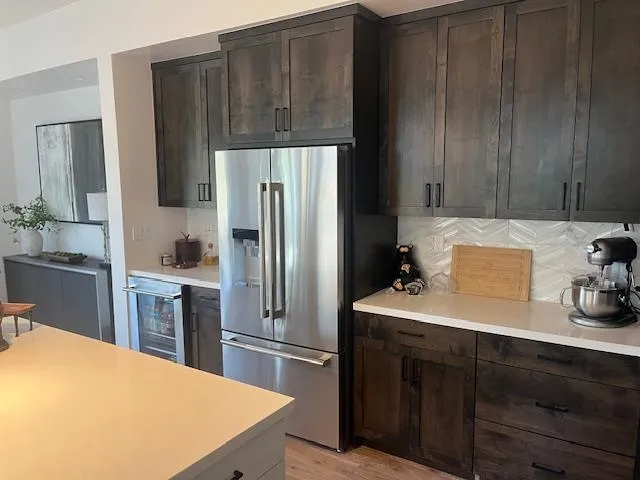 a kitchen with a sink a refrigerator and cabinets