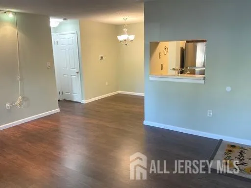 a view of a hallway with wooden floor and a mirror