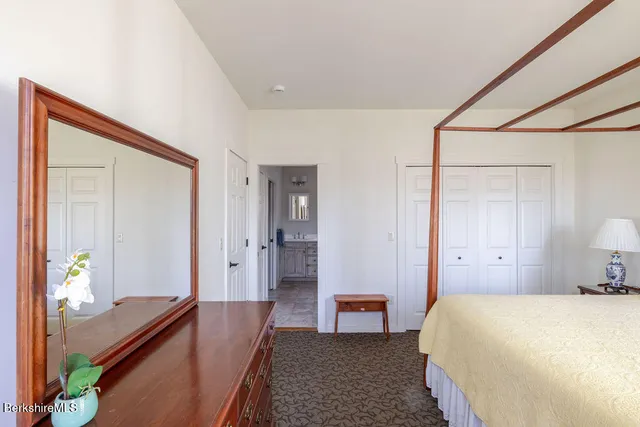 a spacious bedroom with a bed and a dresser