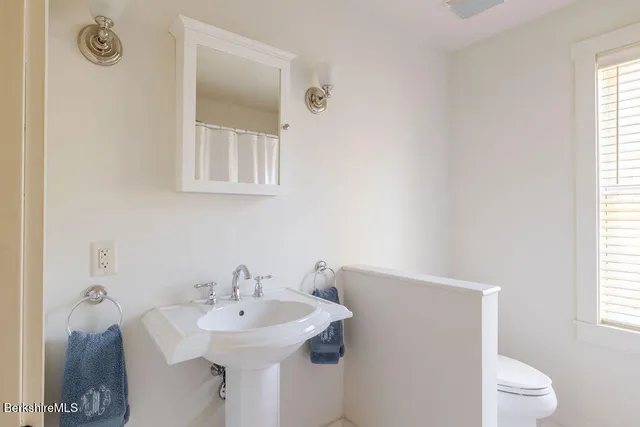 a bathroom with a sink a toilet and a window