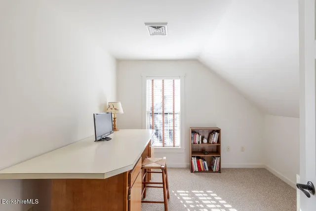a living room with a bed and a book shelf