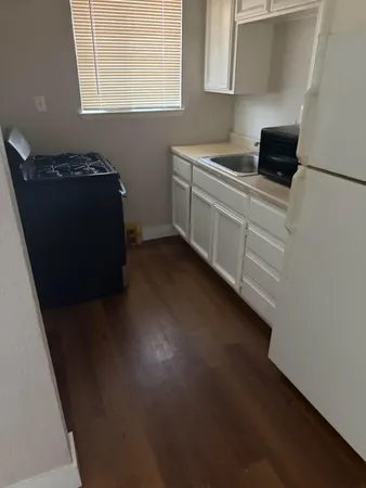 a kitchen with granite countertop white cabinets and black appliances