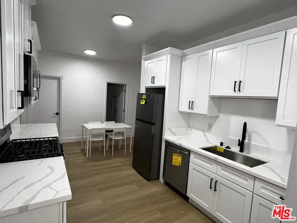 a kitchen with a sink a refrigerator and cabinets