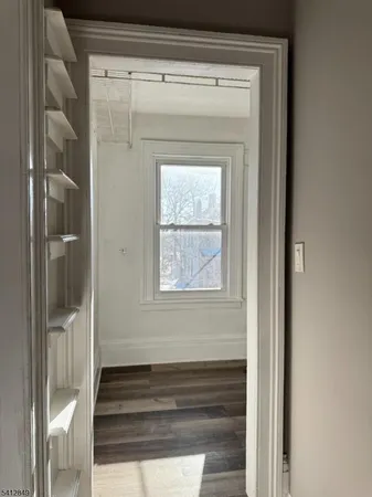 a view of a livingroom with wooden floor and a bathroom
