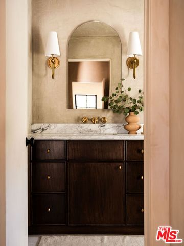 a bathroom with a granite countertop sink a mirror and cabinets