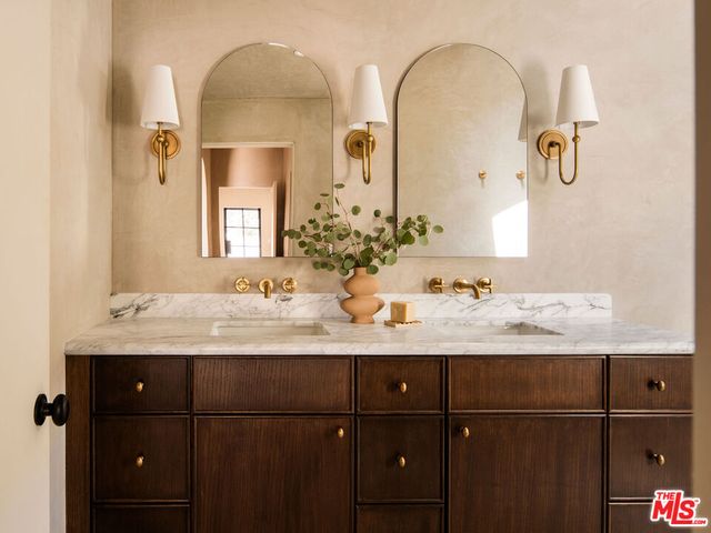 a bathroom with a granite countertop sink a toilet and mirror