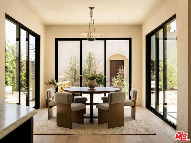 a view of a dining room with furniture large windows and wooden floor