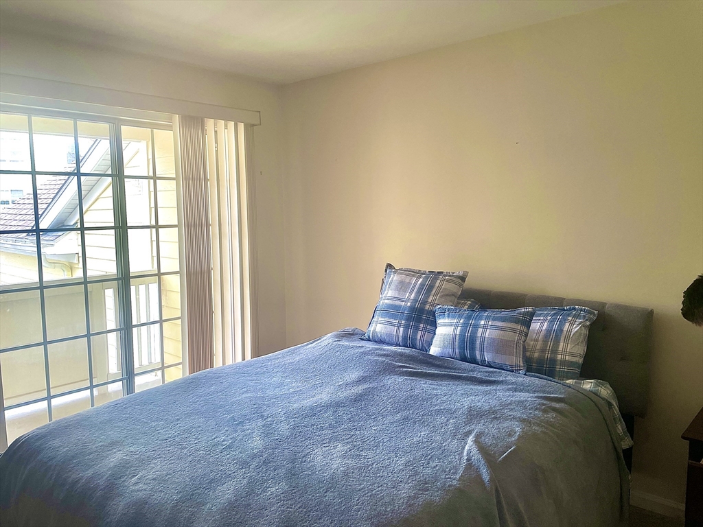 208 Gazebo Circle, Unit 208 Reading, MA 01867 - Photo 8 of 10 a bedroom with a bed and wooden floor