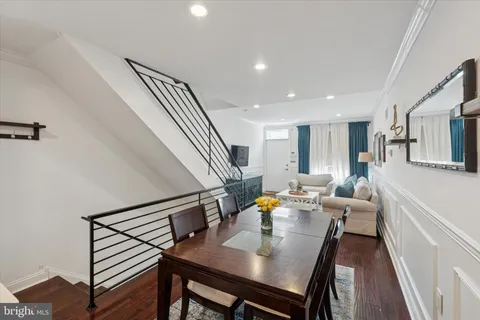 a view of a dining room with furniture a chandelier and wooden floor