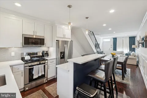 a kitchen with stainless steel appliances a stove a sink island and a refrigerator