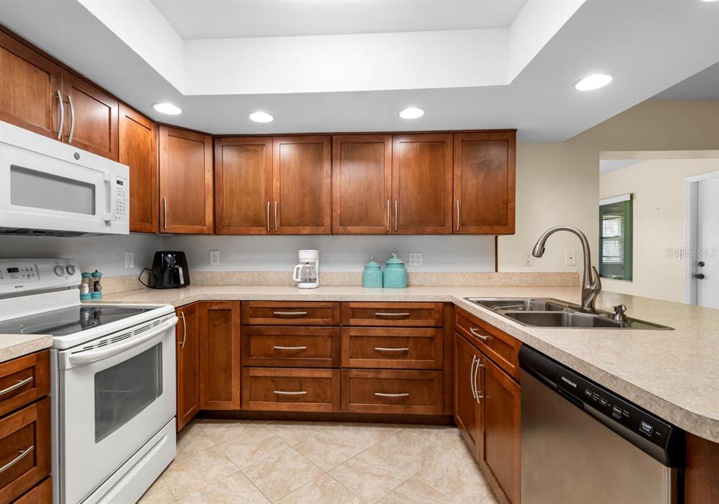 2034 Hawkhurst Circle, Unit 178 Sun City Center, FL 33573 - Photo 19 of 46 a kitchen with stainless steel appliances granite countertop a sink stove and cabinets