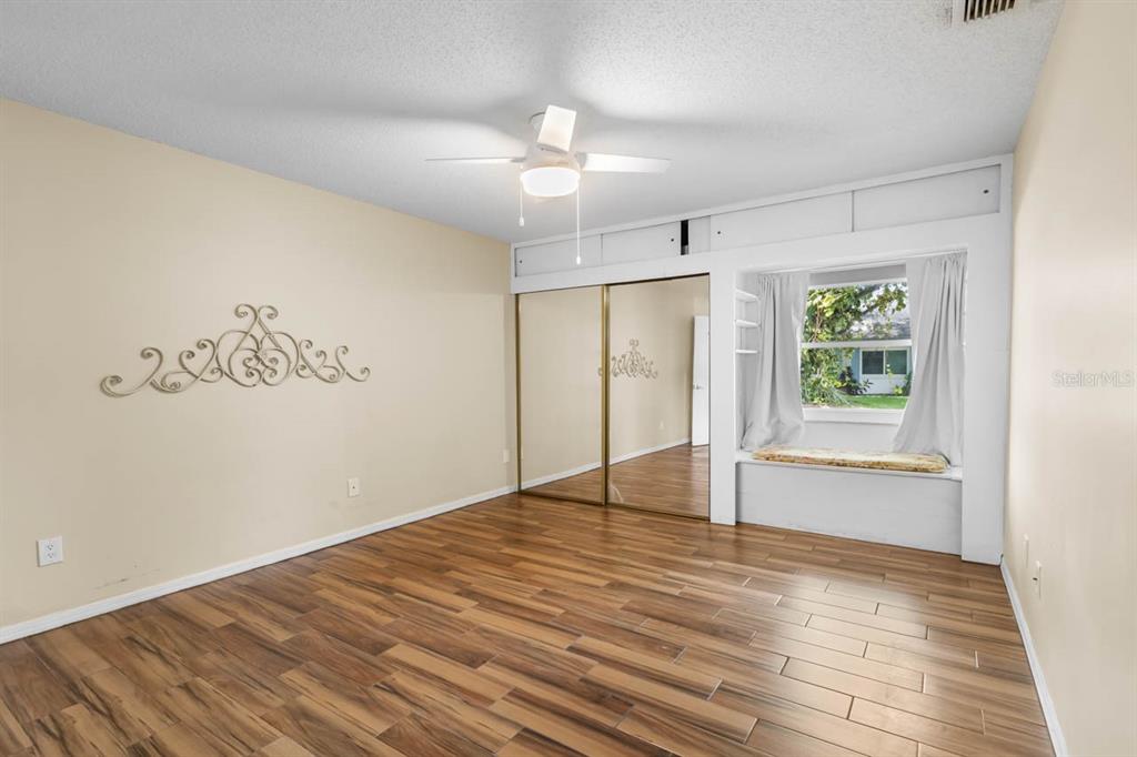 2034 Hawkhurst Circle, Unit 178 Sun City Center, FL 33573 - Photo 25 of 46 an empty room with wooden floor cabinet and windows