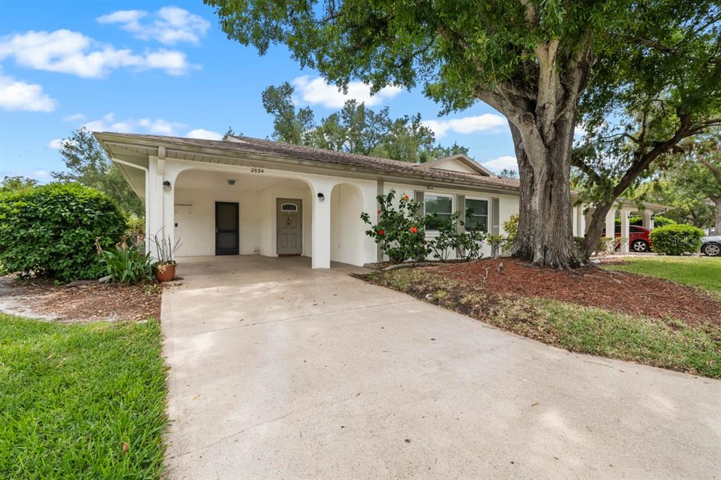 2034 Hawkhurst Circle, Unit 178 Sun City Center, FL 33573 - Photo 37 of 46 a view of a white house with a big yard and large tree