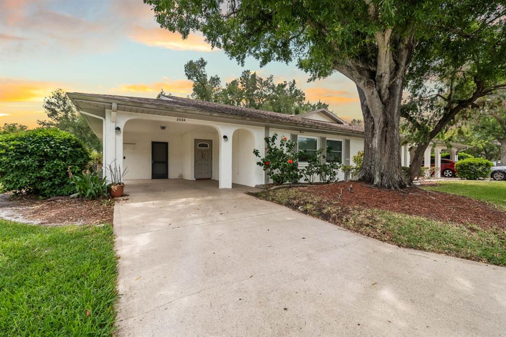 2034 Hawkhurst Circle, Unit 178 Sun City Center, FL 33573 - Photo 38 of 46 a view of a white house with a big yard and large tree