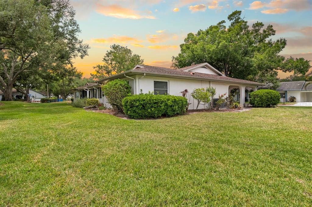 2034 Hawkhurst Circle, Unit 178 Sun City Center, FL 33573 - Photo 42 of 46 a view of a house with a big yard and potted plants and large trees