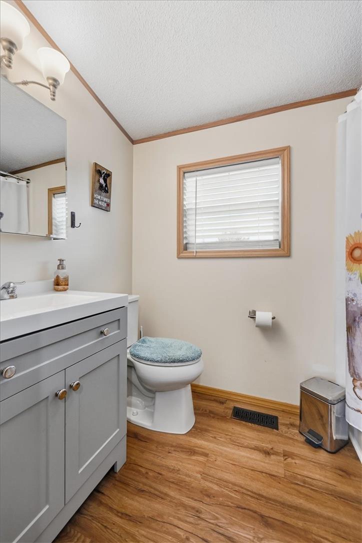 6129 Memorial Road Allentown, PA 18104 - Photo 31 of 46 A windowed bathroom features a classic vanity cabinet alongside clean wood-look flooring.