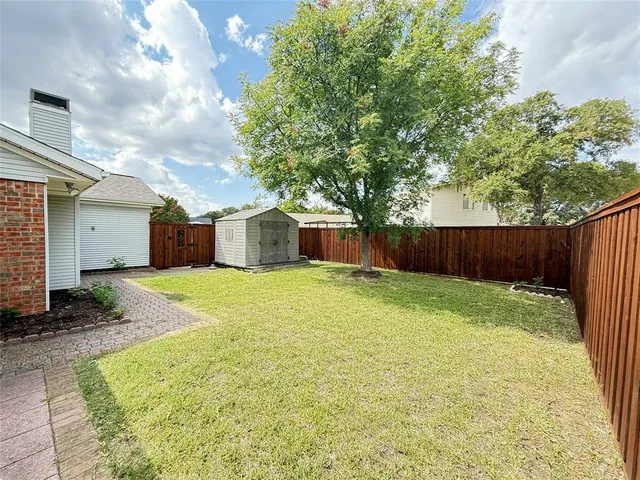 a front view of house with yard and trees in the background