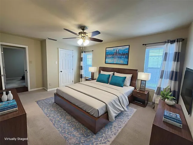 a bedroom with a large bed a chandelier and dresser