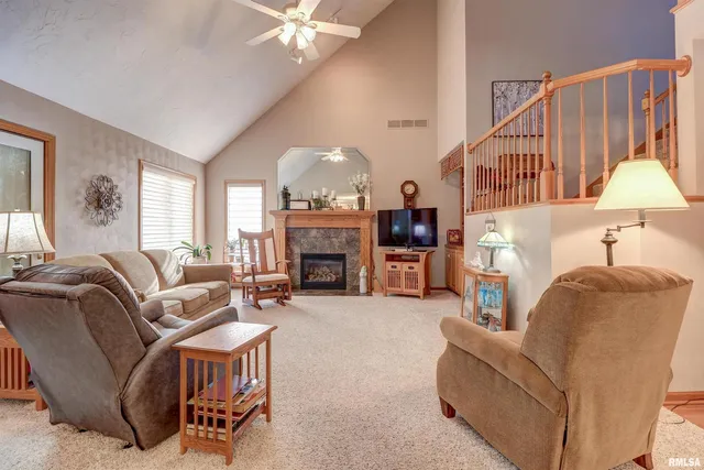 a living room with furniture a fireplace and a chandelier