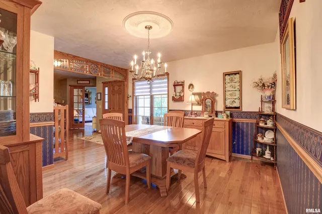 a dining room with furniture a chandelier and wooden floor
