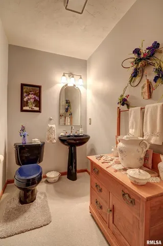 a bathroom with a toilet a sink and a mirror