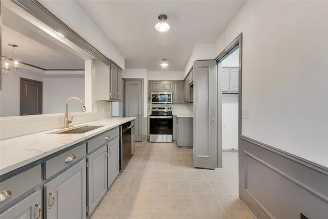 a large kitchen with a large counter top stainless steel appliances and cabinets