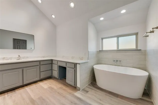 a spacious bathroom with a tub sink and mirror