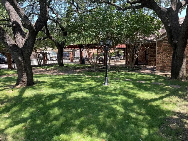 a view of a big house with a big yard and palm trees