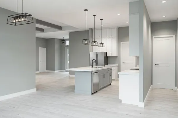 a large white kitchen with a refrigerator a sink dishwasher and a stove