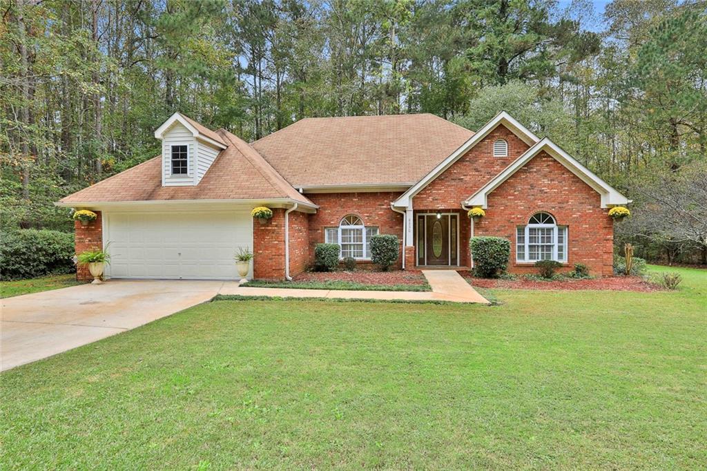8330 Rivertown Road Fairburn, GA 30213 - Photo 1 of 1 a front view of a house with a garden and yard