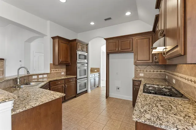 a kitchen with granite countertop a stove and a microwave