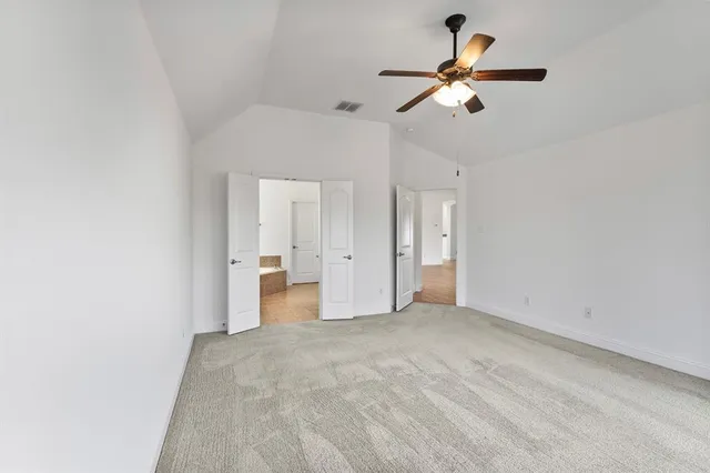 an empty room with a window and a ceiling fan