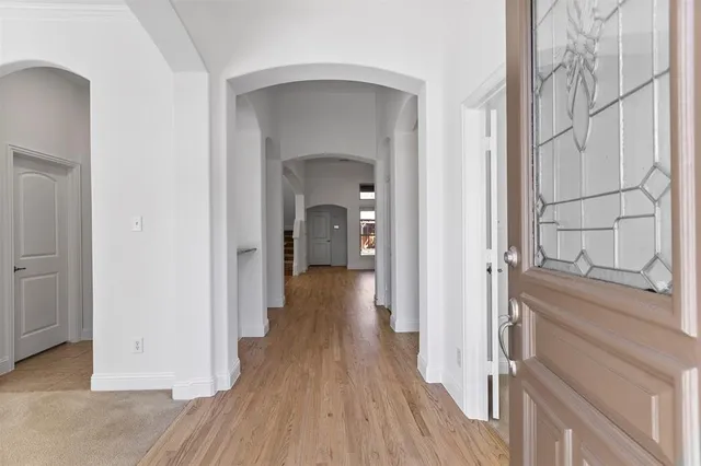 a view of a hallway with wooden floor and a entryway