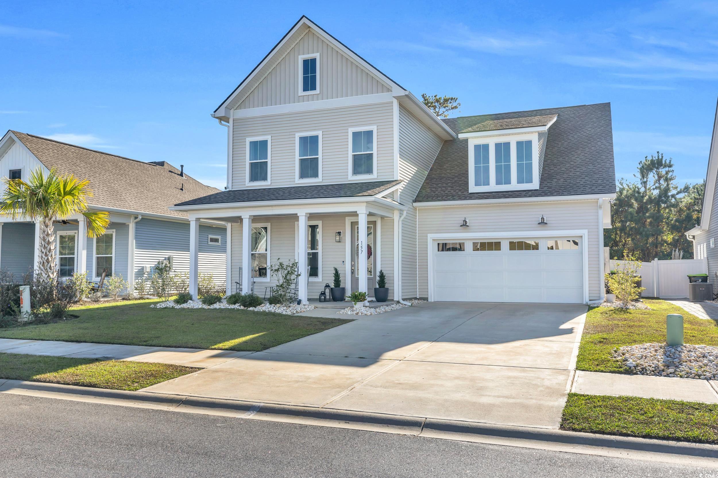 View of front of property with a front lawn, a gar