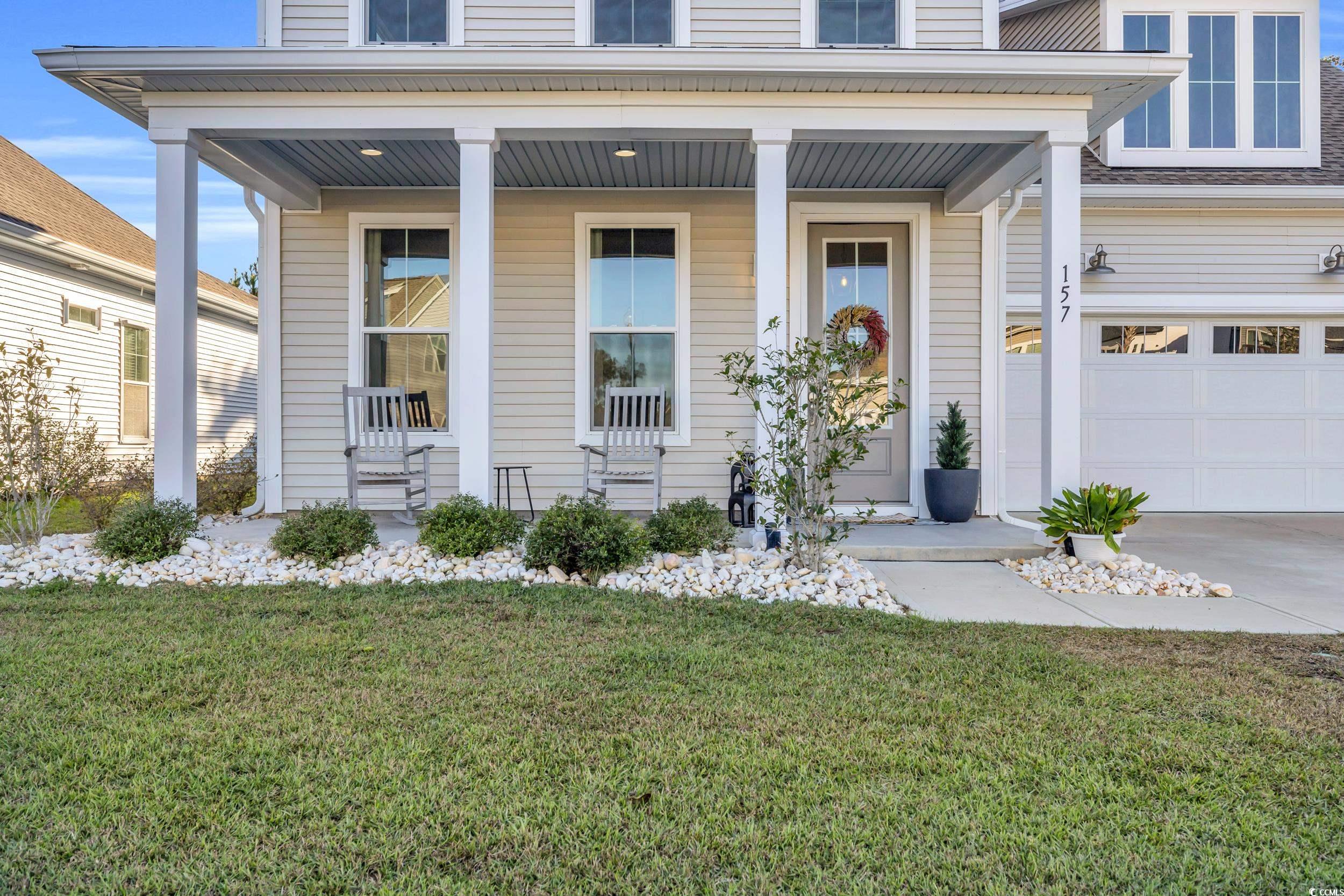 Doorway to property with a garage, covered porch,