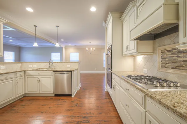 a kitchen with stainless steel appliances granite countertop a stove and a sink