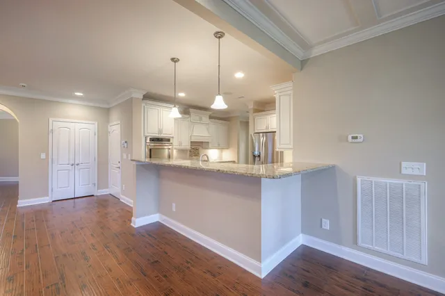 a view of a kitchen with wooden floor and windows