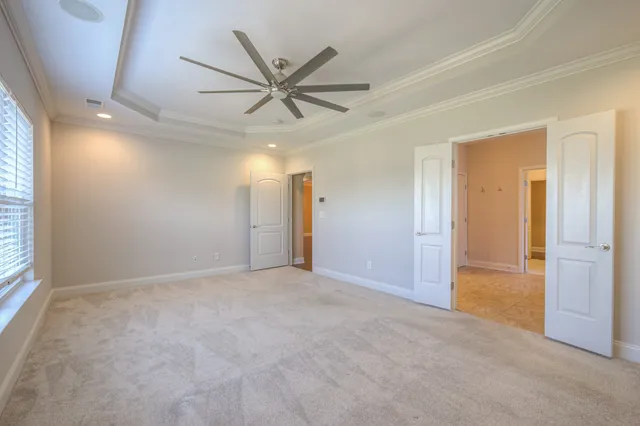 an empty room with fan and windows