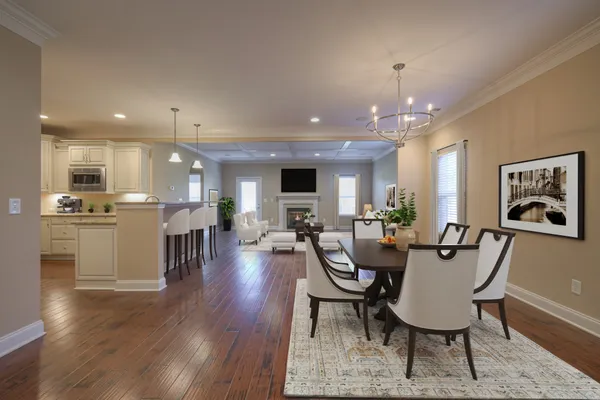 a view of a dining room and livingroom with furniture wooden floor a chandelier