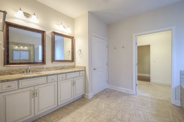 a bathroom with double sink and a mirror