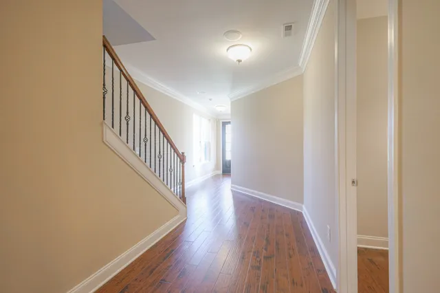 a view of a hallway with wooden floor and entryway