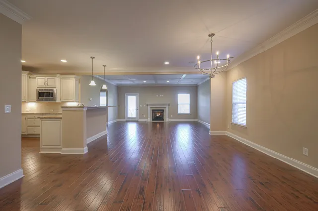 wooden floor in an empty room with a kitchen