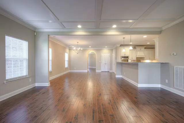 a view of a big room with wooden floor and windows