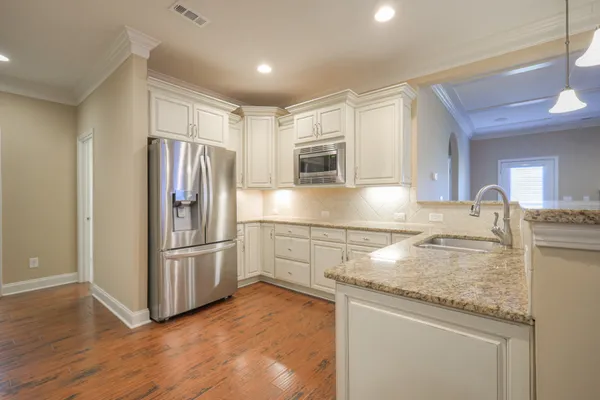 a view of a kitchen with wooden floor and windows