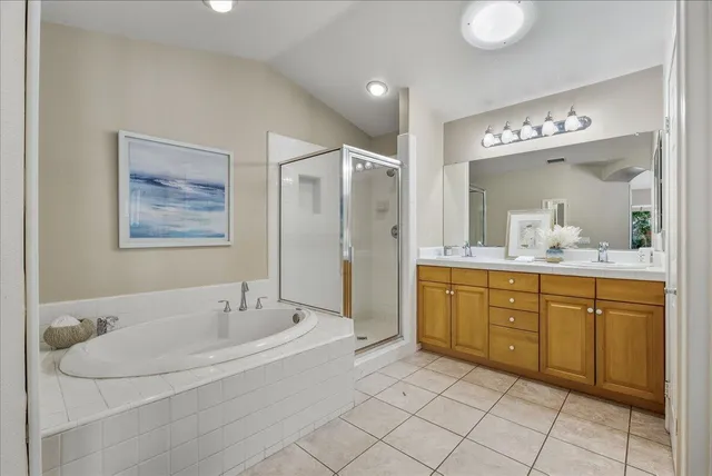 a spacious bathroom with a tub sink and mirror