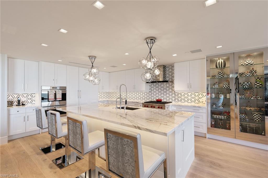 6897 Grenadier Boulevard, Unit 1202 Naples, FL 34108 - Photo 12 of 50 a kitchen with stainless steel appliances granite countertop a sink stove and refrigerator