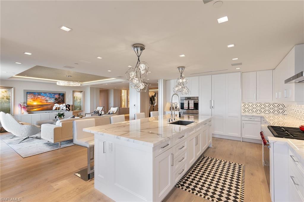 6897 Grenadier Boulevard, Unit 1202 Naples, FL 34108 - Photo 13 of 50 a large white kitchen with a large window and stainless steel appliances