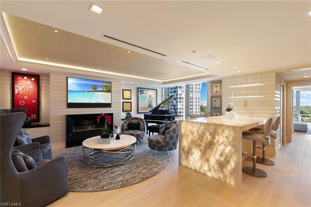 6897 Grenadier Boulevard, Unit 1202 Naples, FL 34108 - Photo 20 of 50 a living room with fireplace furniture and a flat screen tv